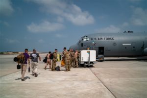 Air Force personnel load relief supplies onto a plane