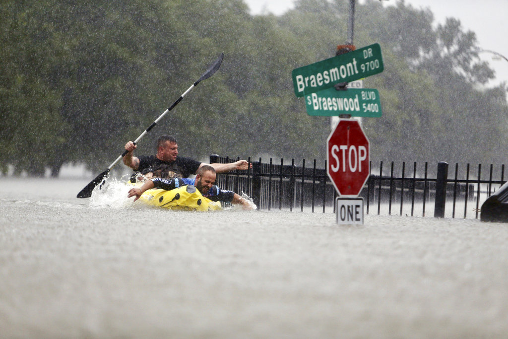 Two kayakers try to beat the current pushing them down an overflowing Brays Bayou from Tropical Storm Harvey in Houston, Texas, Sunday, Aug. 27, 2017. (Mark Mulligan/Houston Chronicle via AP)