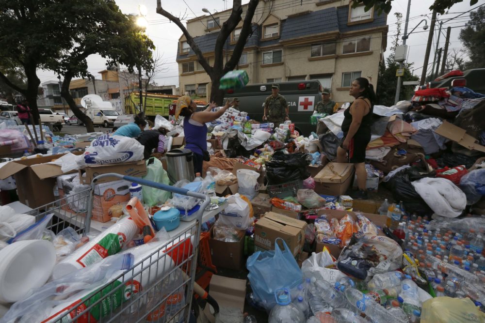 Volunteers organize donated supplies outside the Enrique Rebsamen school that collapsed where search and rescue efforts continue in the aftermath of a 7.1 magnitude earthquak, in Mexico City, Wednesday, Sept. 20, 2017. Police, firefighters and ordinary Mexicans dug frantically through the rubble of collapsed schools, homes and apartment buildings early Wednesday, looking for survivors of Mexico's deadliest earthquake in decades as the number of confirmed fatalities climbs. (AP Photo/Marco Ugarte)
