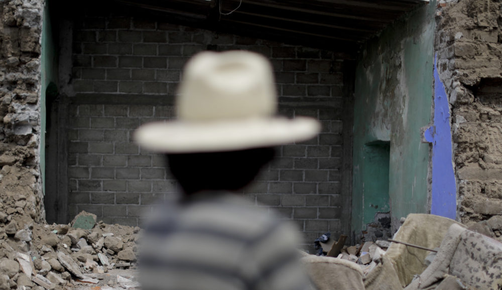 Rafael Rendes stands near his destroyed home after an earthquake, in Tepeojuma, Mexico, Sunday, Sept. 24, 2017. As the search continued Sunday for survivors and the bodies of people who died in quake-collapsed buildings, specialists have fanned out to inspect buildings and determine which are unsafe after Tuesday's powerful earthquake that killed more than 300 people. (AP Photo/Natacha Pisarenko)