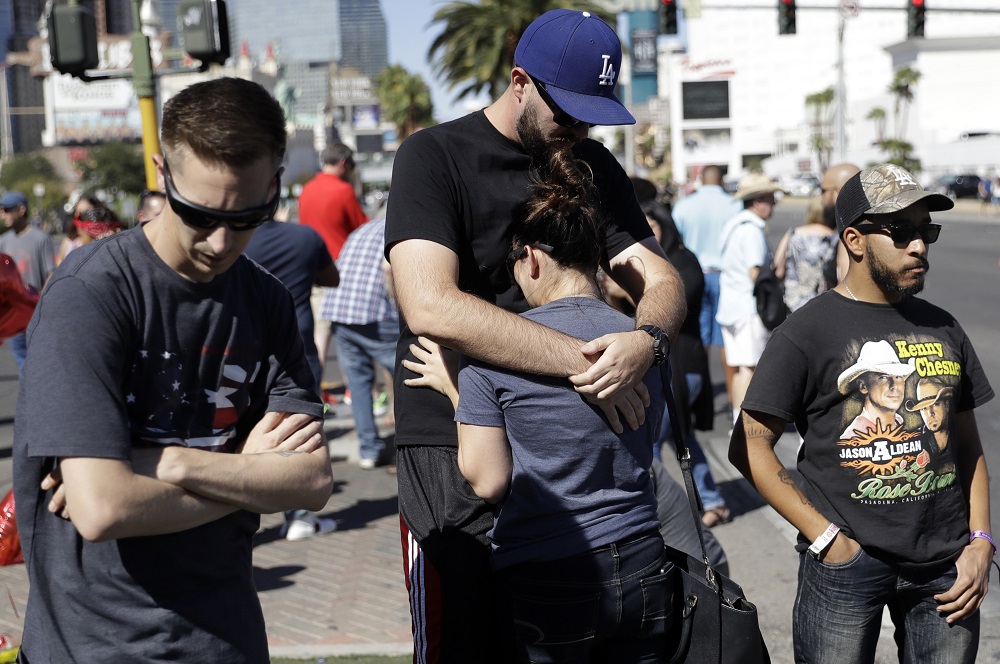 Reed Broschart, center, hugs his girlfriend Aria James on the Las Vegas Strip in the aftermath of a mass shooting at a concert Monday, Oct. 2, 2017, in Las Vegas. The couple, both of Ventura, Calif., attended the concert. (AP Photo/Marcio Jose Sanchez)