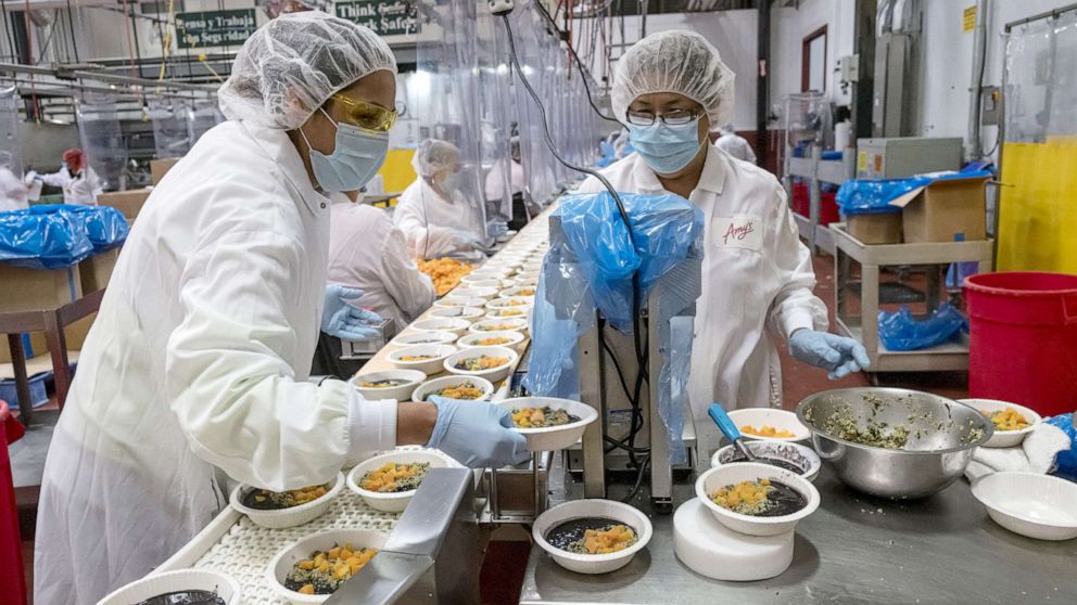 Workers wearing protective masks and food processing clothing perform quality checks at an Amy's Kitchen facility in Santa Rosa Calif., June 24, 2020.